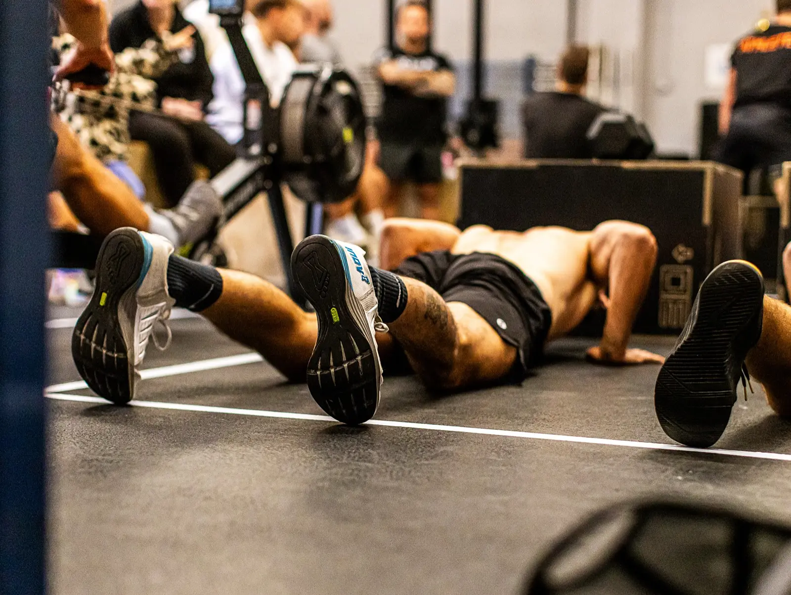 Athlete on the floor after a workout, with a chalked hand in the foreground