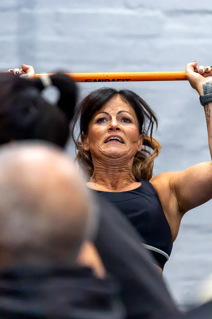 Woman carrying a sandbag across the competition floor