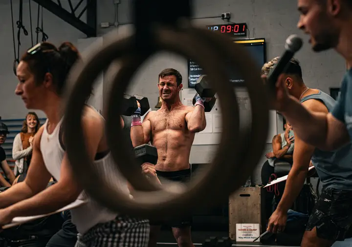 Athlete in a low squat with a barbell, chalk in the air