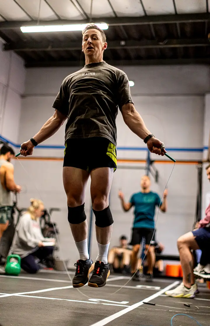Two athletes side by side with barbells