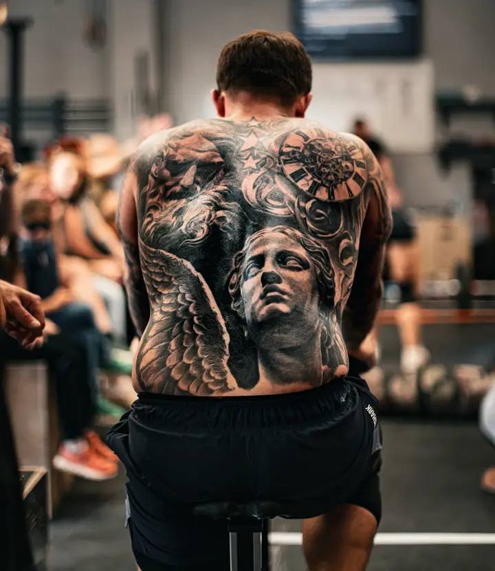 Athlete standing with a barbell, chalk dust around her