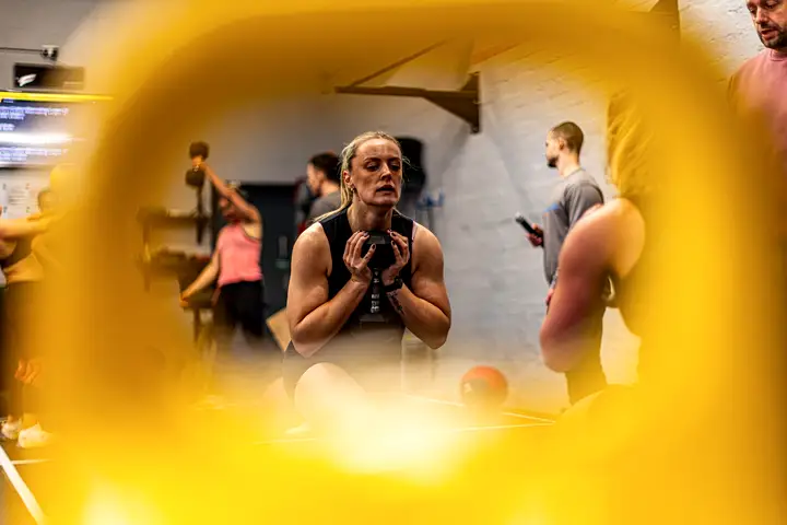 Athlete mid-air on a box jump, chalk dust in the air