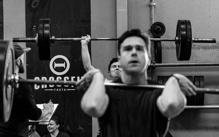 Athlete mid-air on a box jump, shot from behind