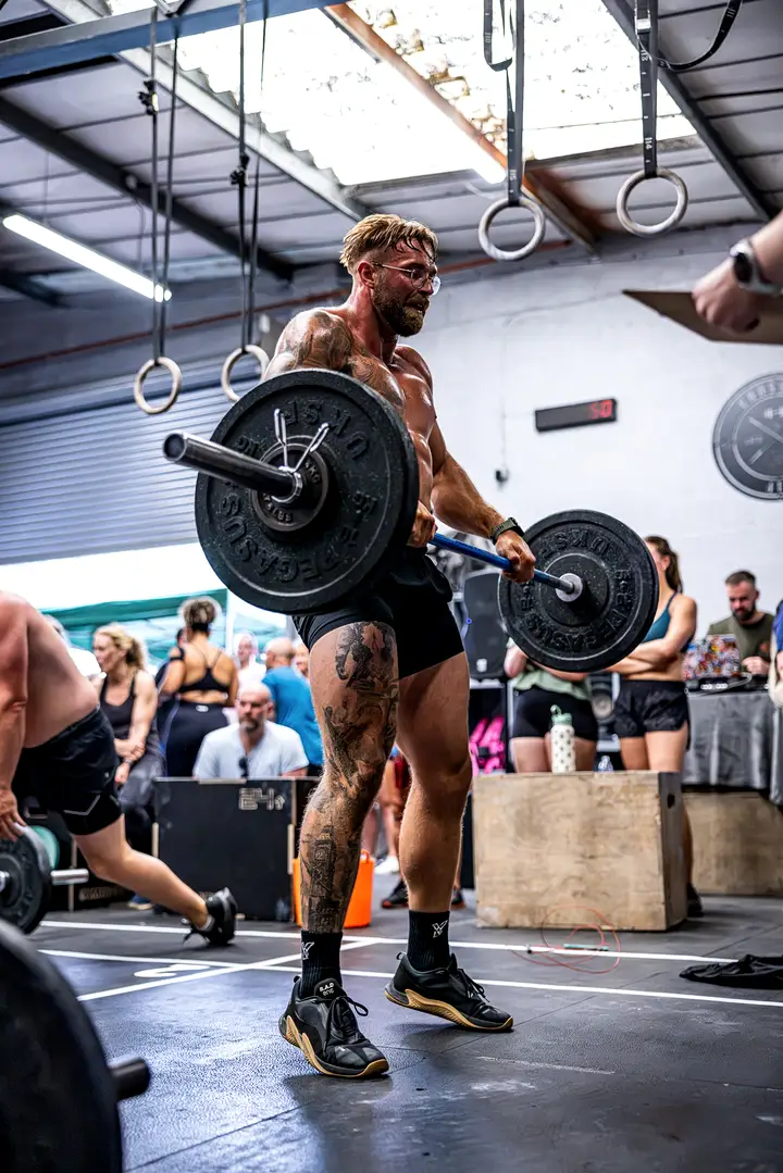 Two athletes side by side in a squat with barbells
