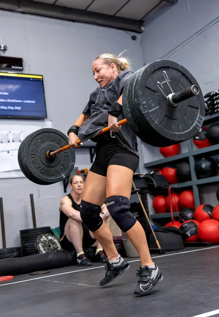 Woman in a lunge with a sandbag on her shoulder